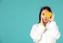 front-view-young-female-bathrobe-holding-orange-slice-blue-background_140725-149850-2112559