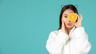 front-view-young-female-bathrobe-holding-orange-slice-blue-background_140725-149850-2112559